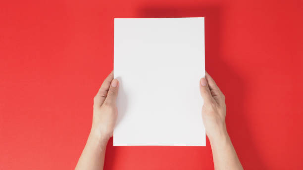 istock hands is holding the white blank A4 paper on red background. 1293205928