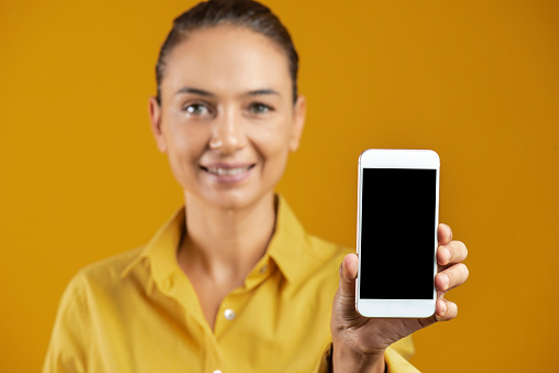 Smiling woman holding smart phone.