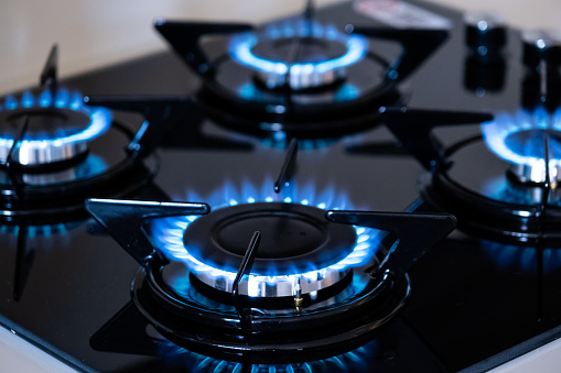 Four kitchen gas stoves burning with natural gas