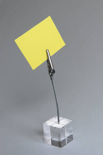 istock Yellow post-it on a transparent cube memo holder on a white background 1293210262