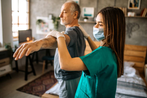 istock Young care nurse helping senior patient doing physical therapy exercises 1293212067