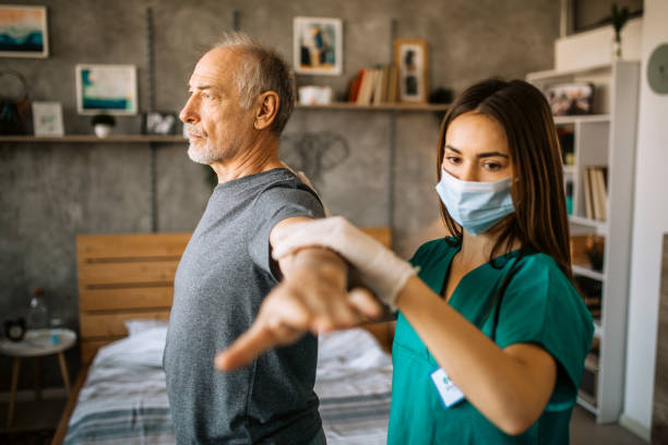 istock Young care nurse helping senior patient doing physical therapy exercises 1293212207