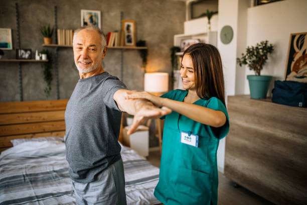istock Young care nurse helping senior patient doing physical therapy exercises 1293212246