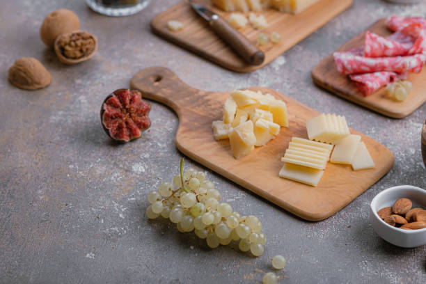 Assorted cheese, salumi, nuts on wooden boards, copy space.