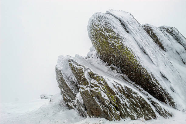 An ancient stone covered with snow on a mountain in Romania