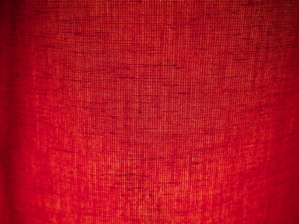 Red abstract background made of fabric. Macro image. Weaving tap-colored pits with black shadows and vignettes. Background for Christmas, New Year, Valentine's Day. Red abstract background made of fabric. Macro image. Weaving tap-colored pits with black shadows and vignettes. Background for Christmas, New Year, Valentine's Day. multi colored woven macro mesh stock pictures, royalty-free photos & images