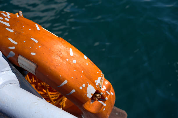 Orange life belt with paint splash hanging on a ship's railing in open waters