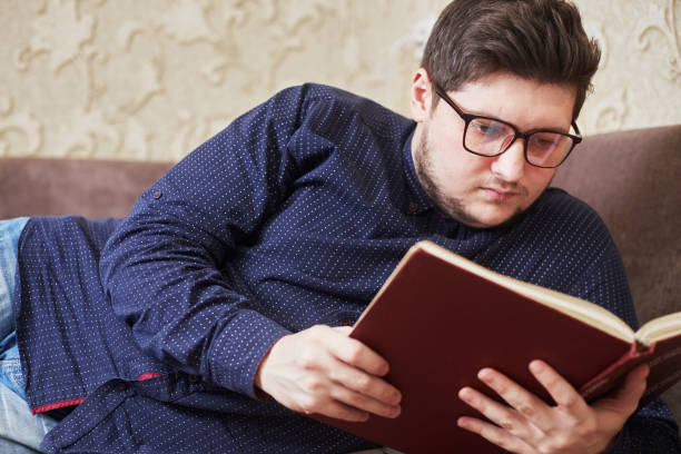 istock caucasian man with glasses reading a book, copy space 1293222398