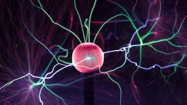 istock Plasma ball lamp close up, electric rays from the ball on black background. Tesla Coil experiment with electricity. Beautiful dynamic abstract light background in colors. 1293225421