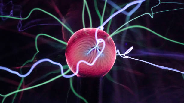 istock View of plasma ball with moving energy rays inside on black background. Abstract lightning in colors. Electricity in gas. 1293225425