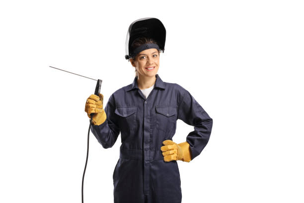 young female welder in a uniform with a welding machine and a helmet - manual worker portrait helmet technology imagens e fotografias de stock
