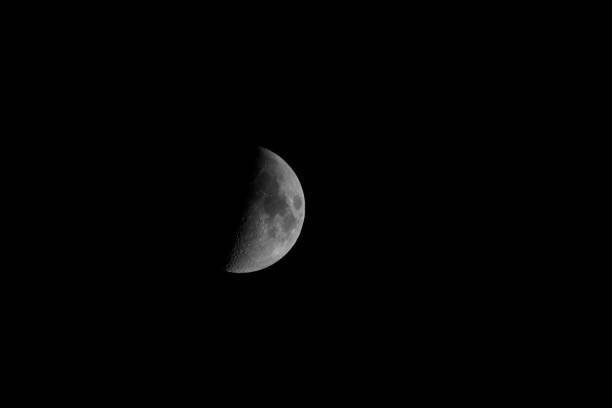 istock First quarter moon over dark black sky seen with a telescope 1293261490