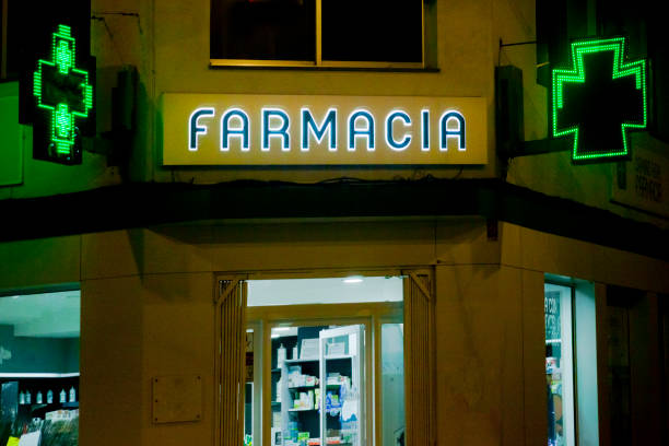 Pharmacy sign in spanish language and green crosses Pharmacy sign in spanish language. Night view, green cross signs. Galicia, Spain. farmacia stock pictures, royalty-free photos & images