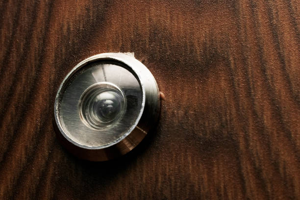 Peephole at the door with a wooden texture close up