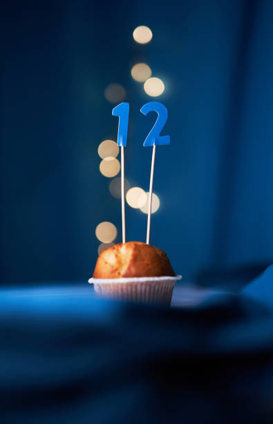 istock Cupcake with number twelve (12) on blue background with lights 1293266441