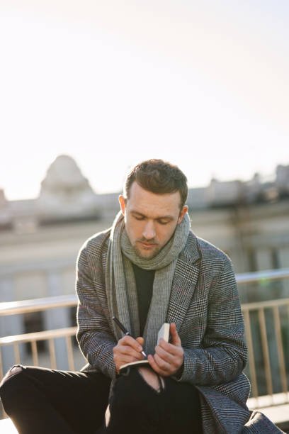 istock Young business man sitting and writing to the notepad 1293266458