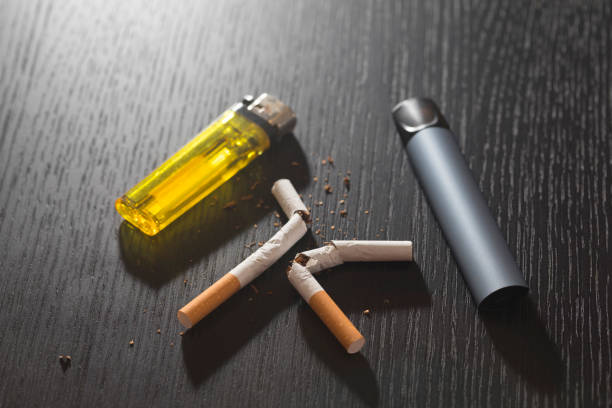 istock Electronic smoke device and cigarette and lighter on black background. 1293267050