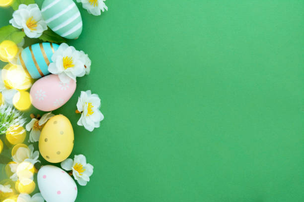 istock Easter eggs and flowers on green background flat lay with copy space 1293274309