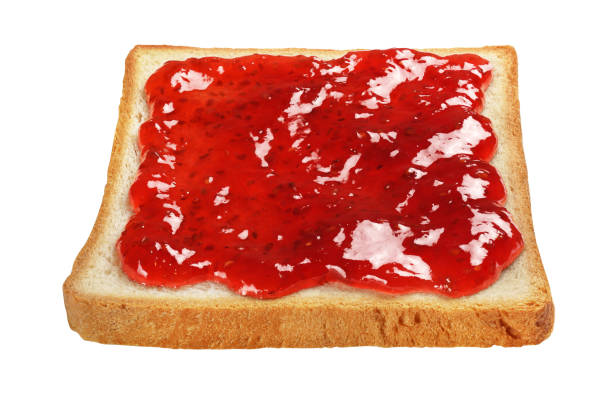 istock Slice of toasted bread with red jam isolated on white. 1293275173