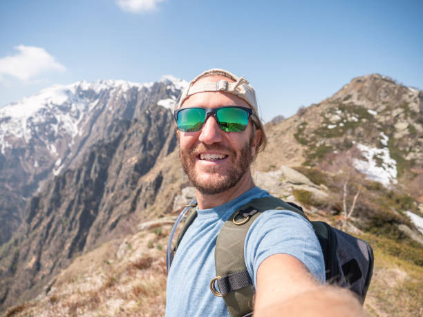 istock Cheerful young man taking a selfie portrait on mountain top 1293275631
