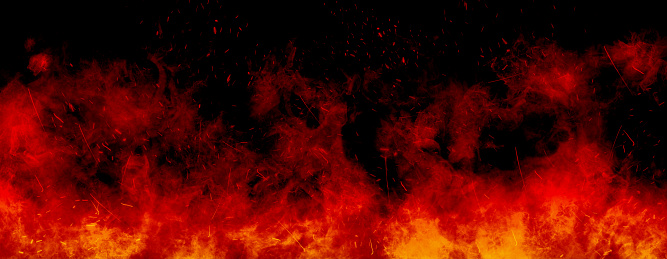 Abstract image of Orange fire or flames with sparkles and smoke in black background.