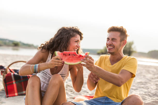 istock Cheerful couple laughing while sharing a slice of watermelon 1293281065