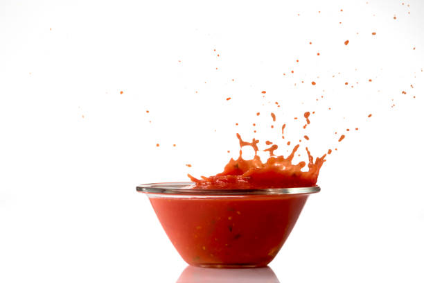 tomato sauce splashing from glass bowl