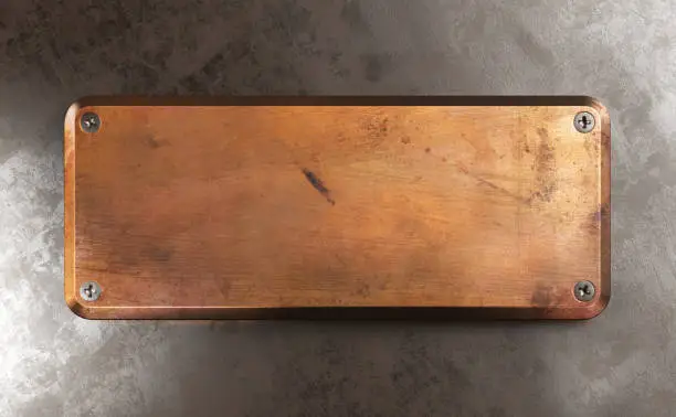 Photo of Empty copper metal plate on rust background.