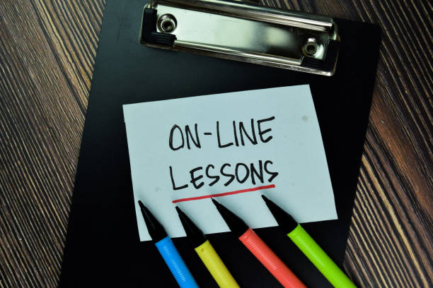 istock On-Line Lesson write on sticky note and isolated on Wooden Table. Educational Concept 1293283676