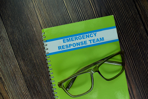 The Book of Emergency Response Team isolated on wooden table