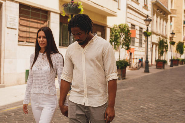 istock Couple holding hands while walking down the city street 1293285865