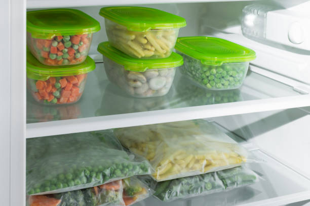 istock Plastic containers and bags with different frozen vegetables in refrigerator. 1293289265
