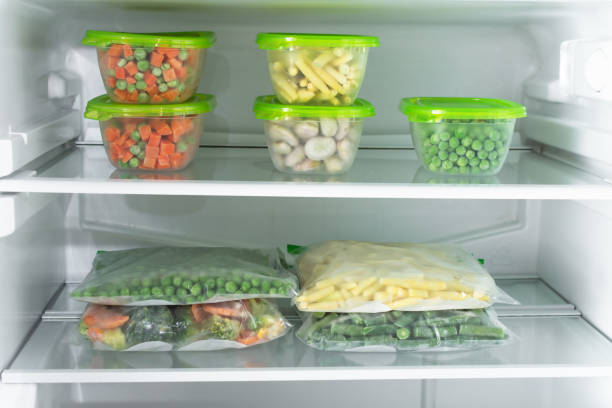 istock Plastic containers and bags with different frozen vegetables in refrigerator. 1293289274