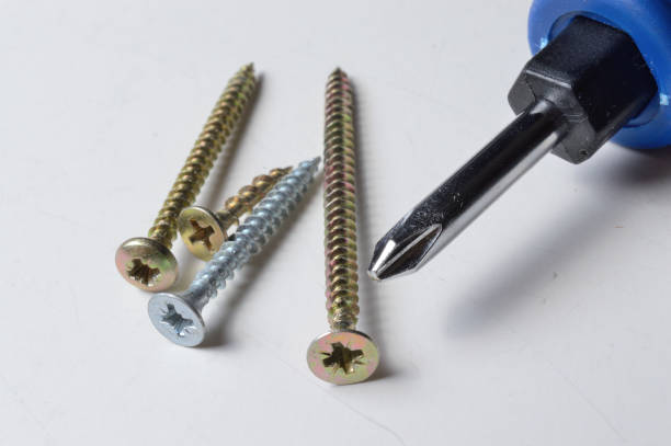 istock A small screwdriver and a few screws on a white background. close-up. 1293291205