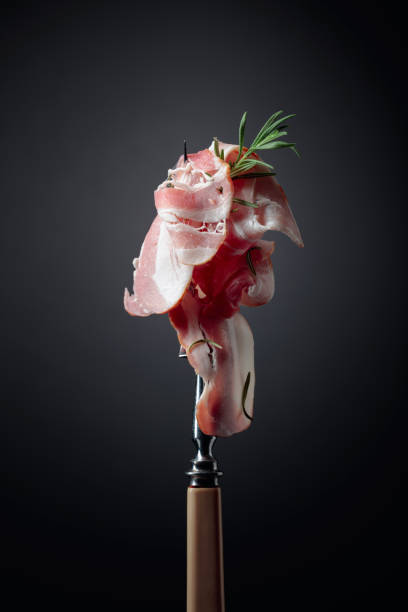 istock Bacon slices and rosemary on a fork. 1293293600