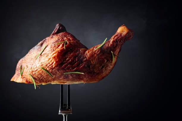 istock Smoked chicken thigh on a fork sprinkled with rosemary. 1293294617