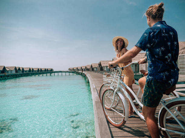 istock Couple cycle on tropical island pier 1293296417