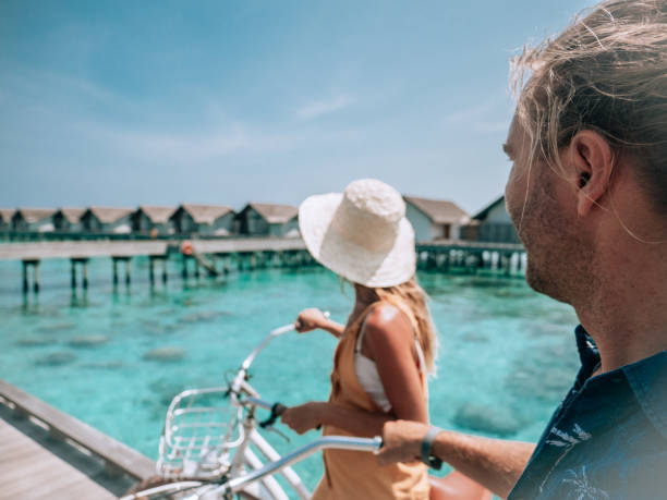 istock Couple cycle on tropical island pier 1293296479