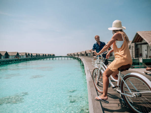 istock Couple cycle on tropical island pier 1293296550