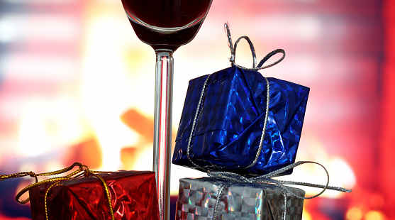 glass of wine and gift boxes in front of the fireplace