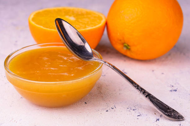 confiture orange organique dans un bol en verre sur une table blanche. plan rapproché. - polish bread photos et images de collection