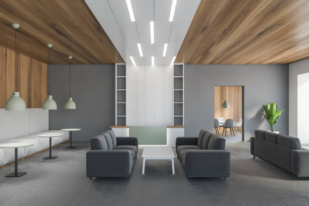 istock Wooden and grey waiting room with grey sofa and reception desk 1293303693