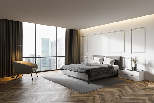 Corner of modern master bedroom with white walls, wooden floor, comfortable king size bed and armchair. 3d rendering