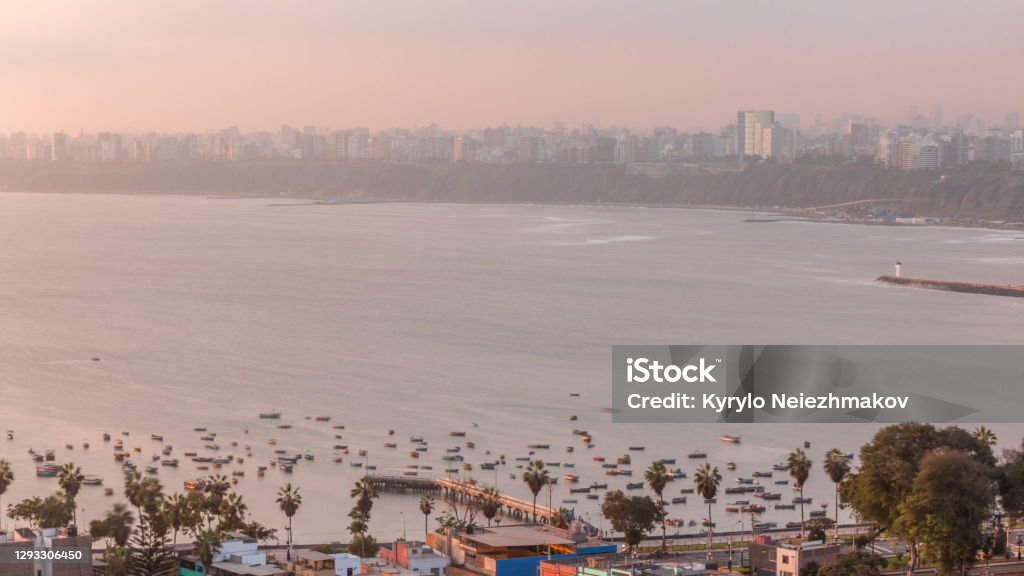 Aerial view of Lima's shoreline with boats including the districts of Barranco and Chorrillos timelapse. Peru Aerial view of Lima's shoreline including the districts of Barranco and Chorrillos on background timelapse. Early morning during sunrise with many boats floating on waves in harbor. Peru Architecture Stock Photo