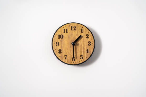 istock wood office wall clock with white dial on white background. wall clock on white background, top view. 1293307693