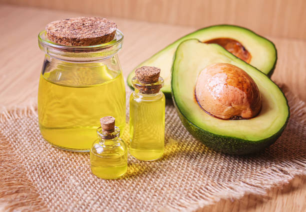 istock Avocado and avocado oil on wooden background. Selective focus 1293307931