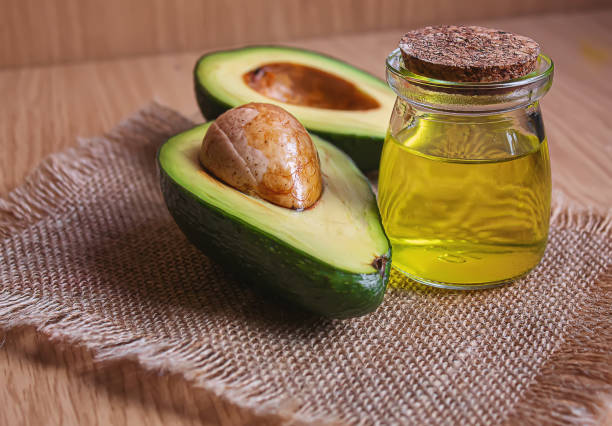 istock Avocado and avocado oil on wooden background. Selective focus 1293307936