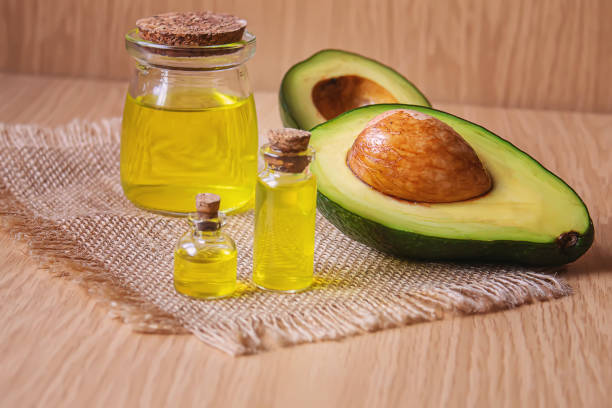 istock Avocado and avocado oil on wooden background. Selective focus 1293307937