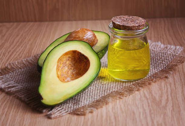 istock Avocado and avocado oil on wooden background. Selective focus 1293307951