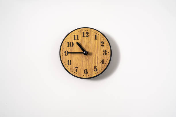 istock wood office wall clock with white dial on white background. wall clock on white background, top view. 1293308474